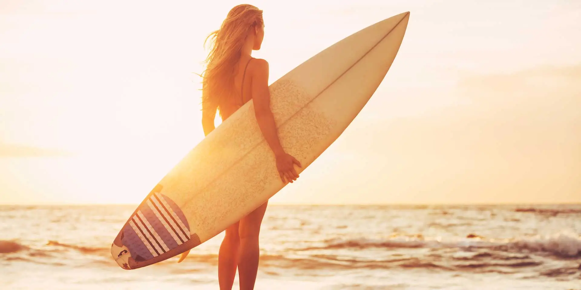 surfer girl looking into the sunset